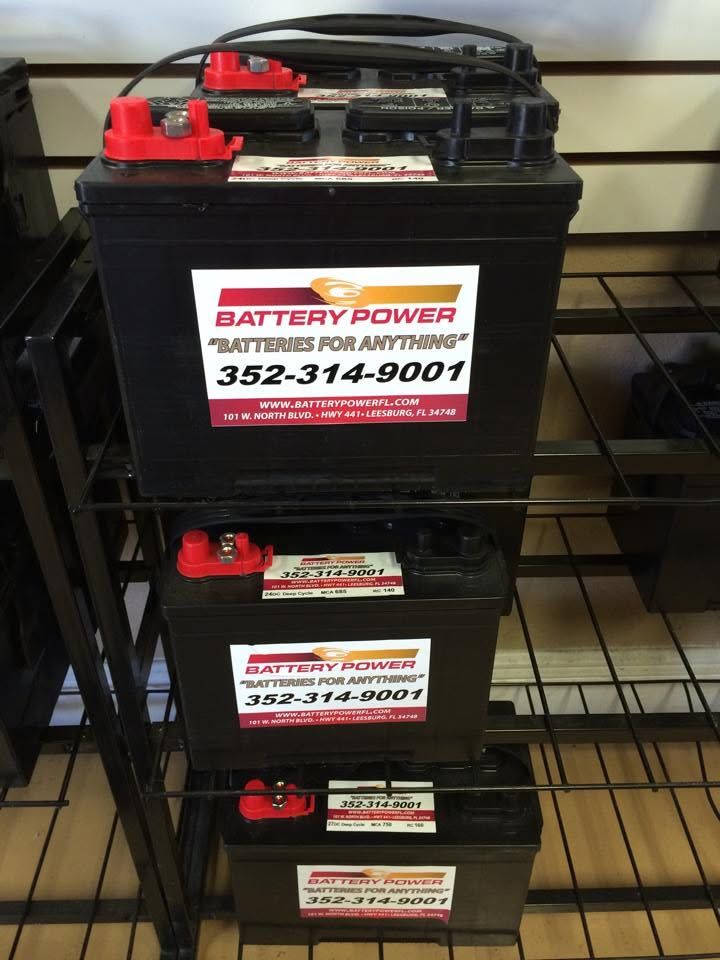 Stacked black batteries with red terminals and 