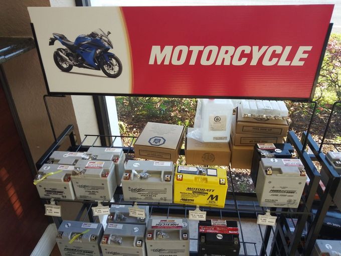 Motorcycle shop display with boxed products under a red “MOTORCYCLE” sign