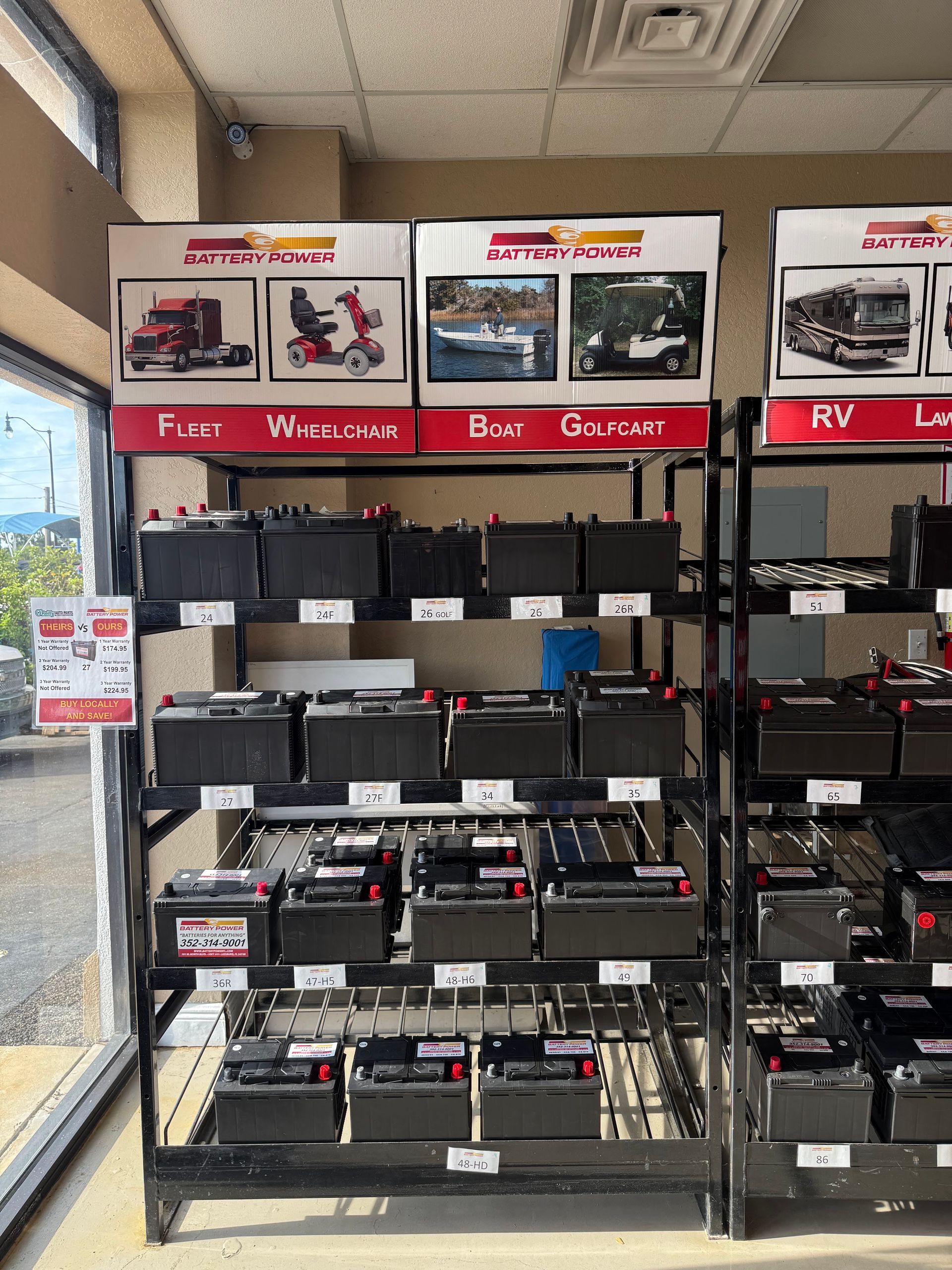Batteries displayed on store shelves, labeled for farm, truck, bus, golf cart and RV use