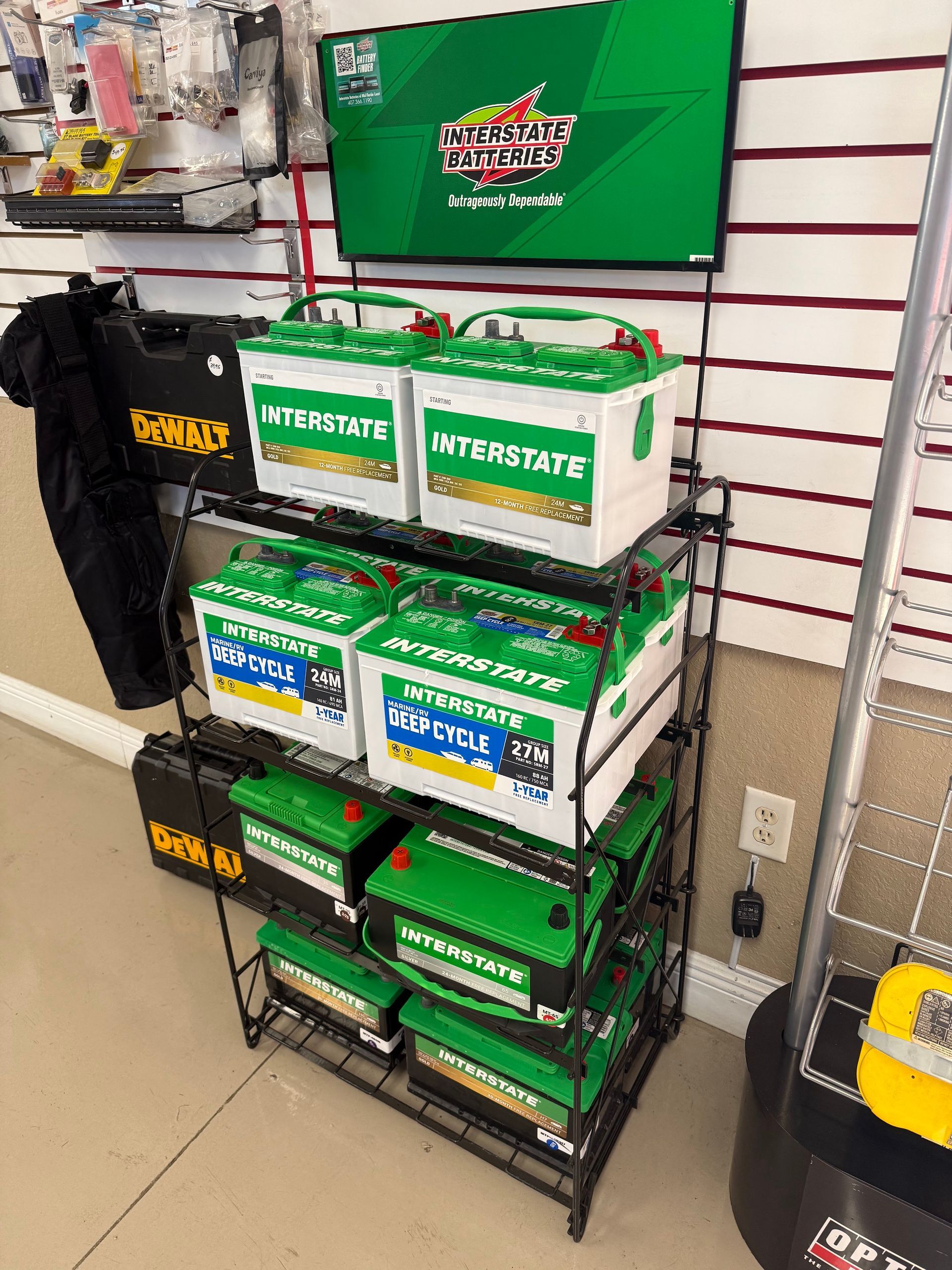 Display rack with green-and-white product boxes in a store aisle next to black merchandise stands.