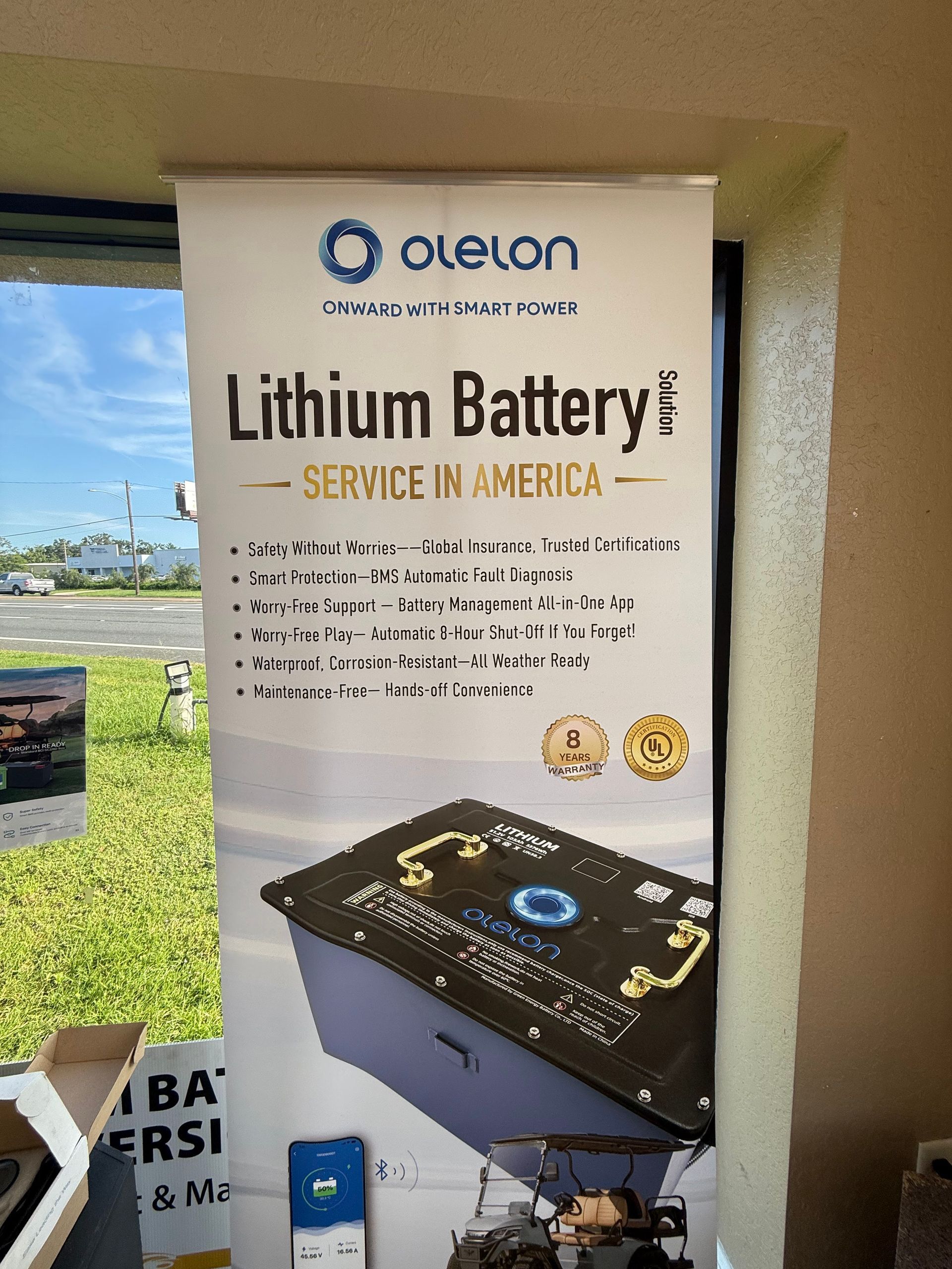 Lithium battery service poster with product photo and branding on a wall display.