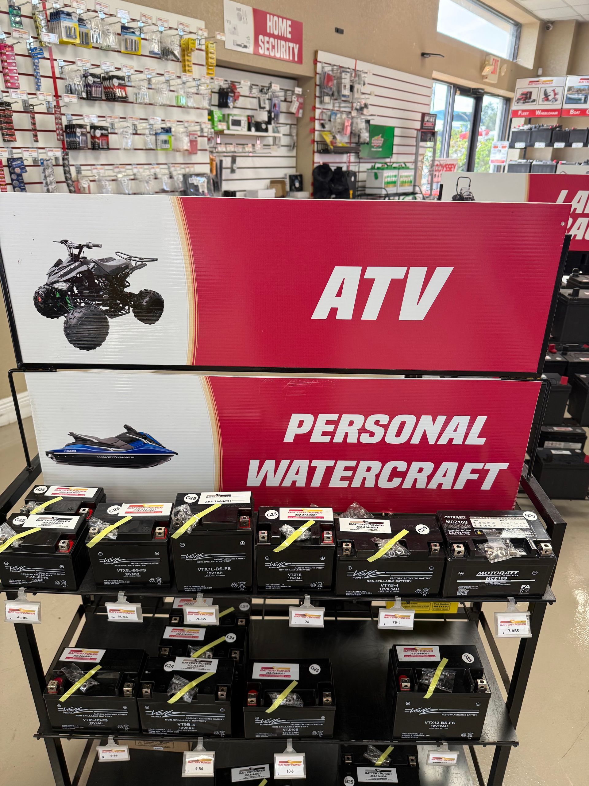 ATV and personal watercraft display in a store, with red signs and stacked boxed models