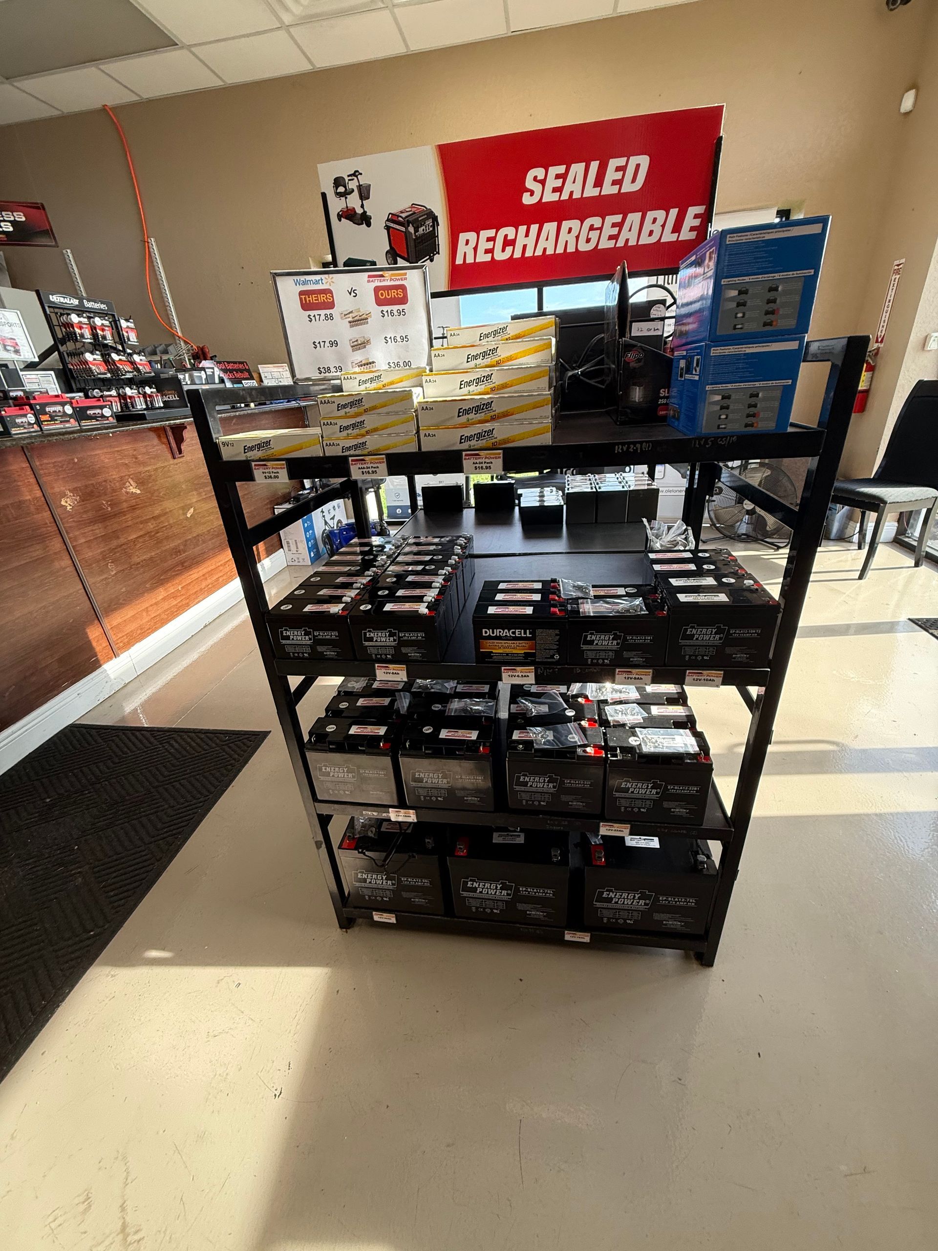 Retail display of sealed rechargeable battery packs on black shelves in a store aisle