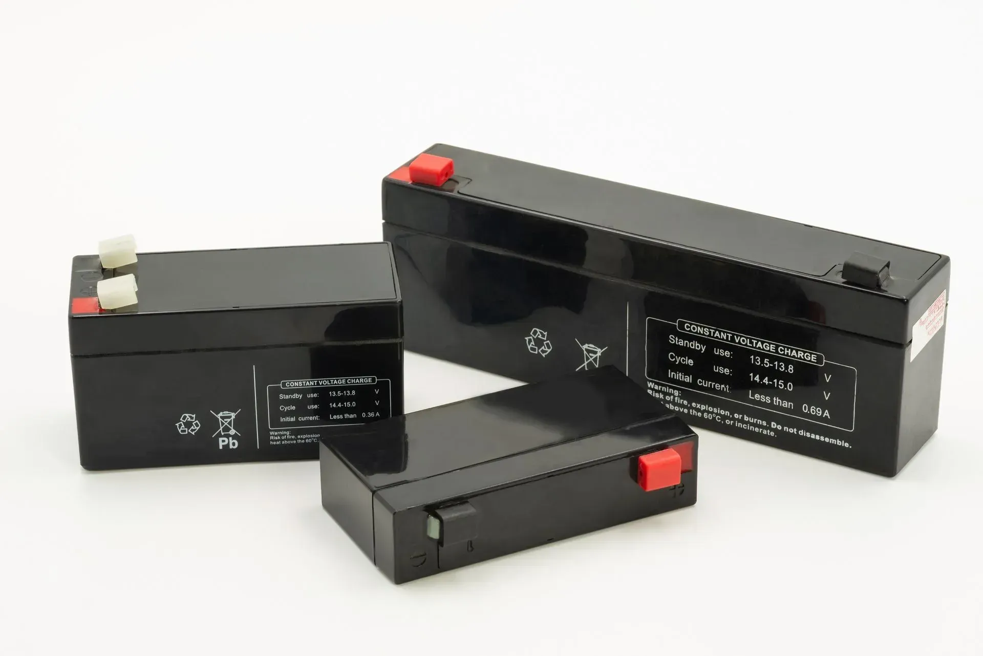 Three black rectangular batteries with red and white terminals on a white background