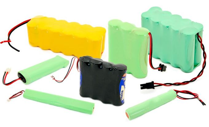 Battery display on a store shelf with black, white, and gray car batteries and price tags