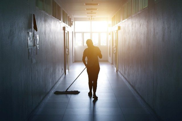 worker cleaning hallway - leysons cleaning products used in commercial buildings