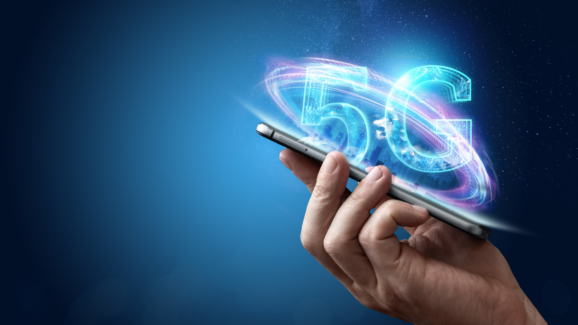 Hand holding a smartphone with glowing blue 5G hologram on a dark background