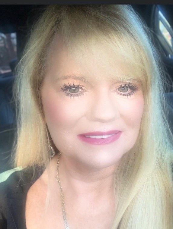 A close up of a woman 's face with blonde hair and pink lipstick.