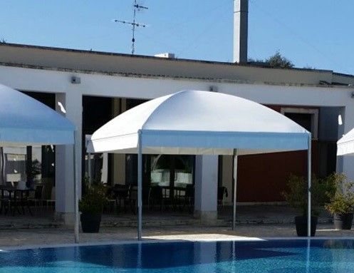 Una piscina con una tenda bianca davanti