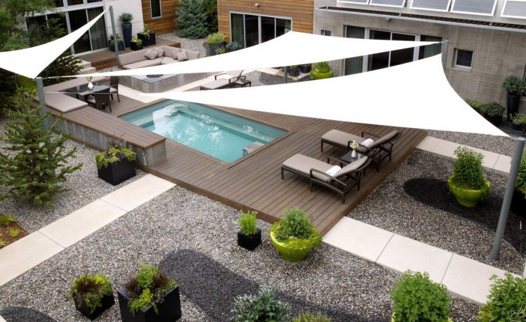 Una vista aerea di un cortile con piscina e ombrelloni