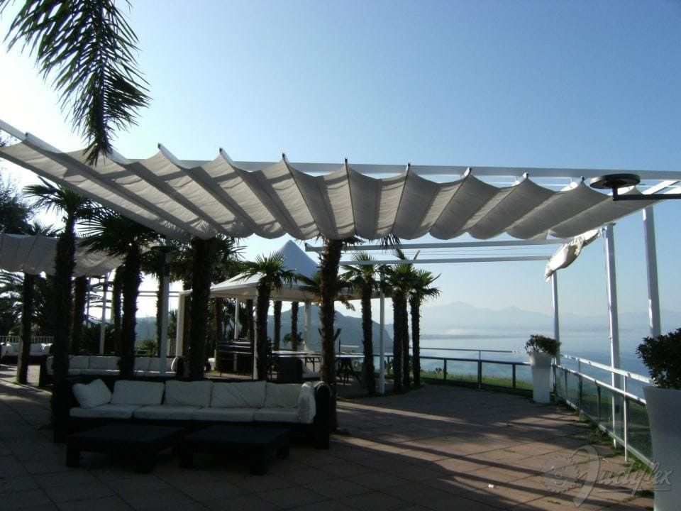 Un patio con una tettoia sopra e una vista sull'oceano