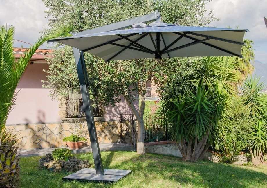 Un grande ombrellone è posizionato al centro di un rigoglioso giardino verde.