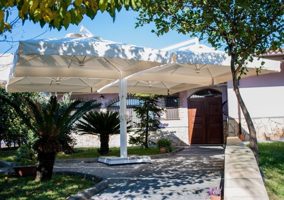 Un grande ombrello bianco è appoggiato davanti a una casa.