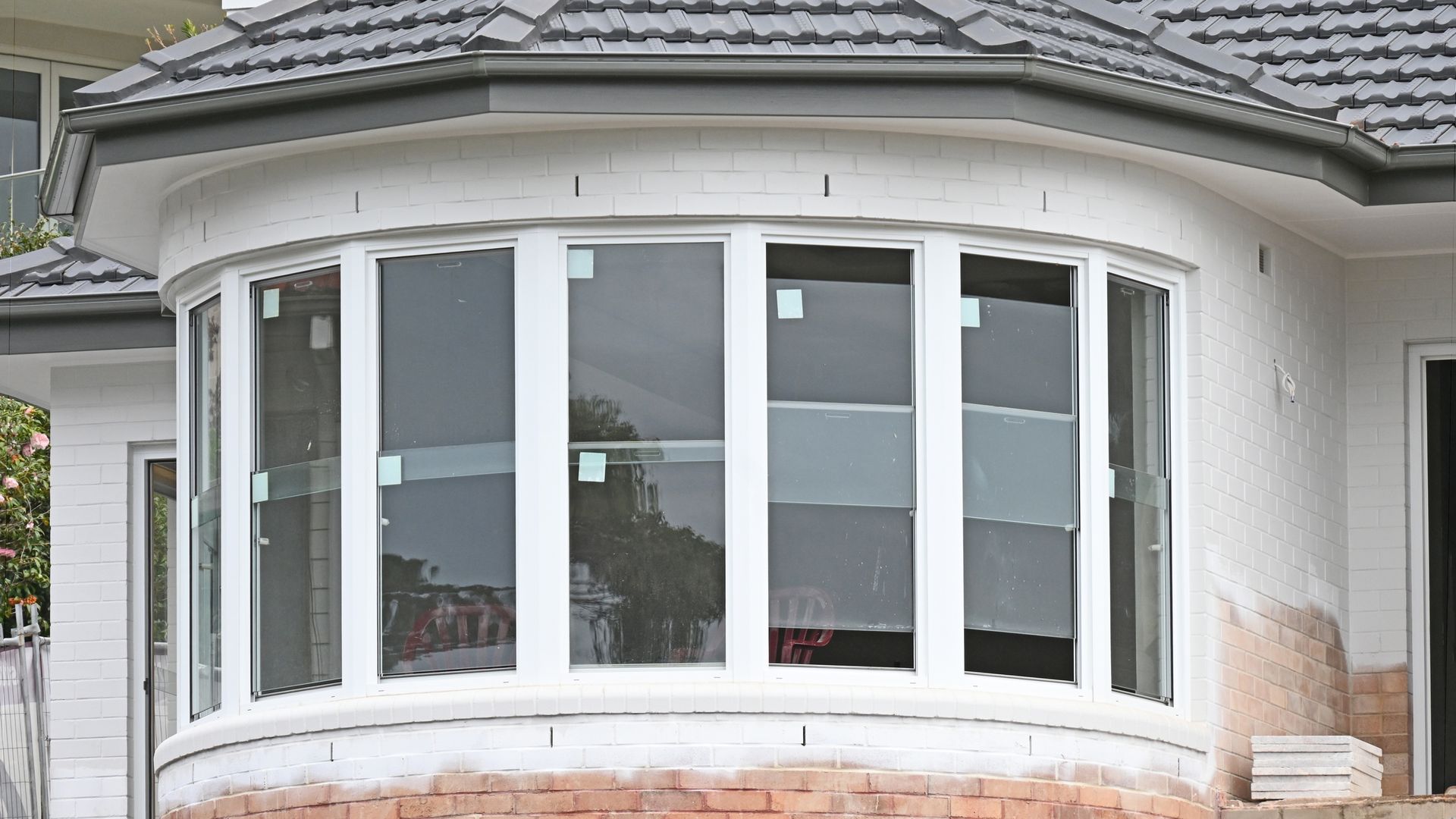 A building being renovated with new bow windows.