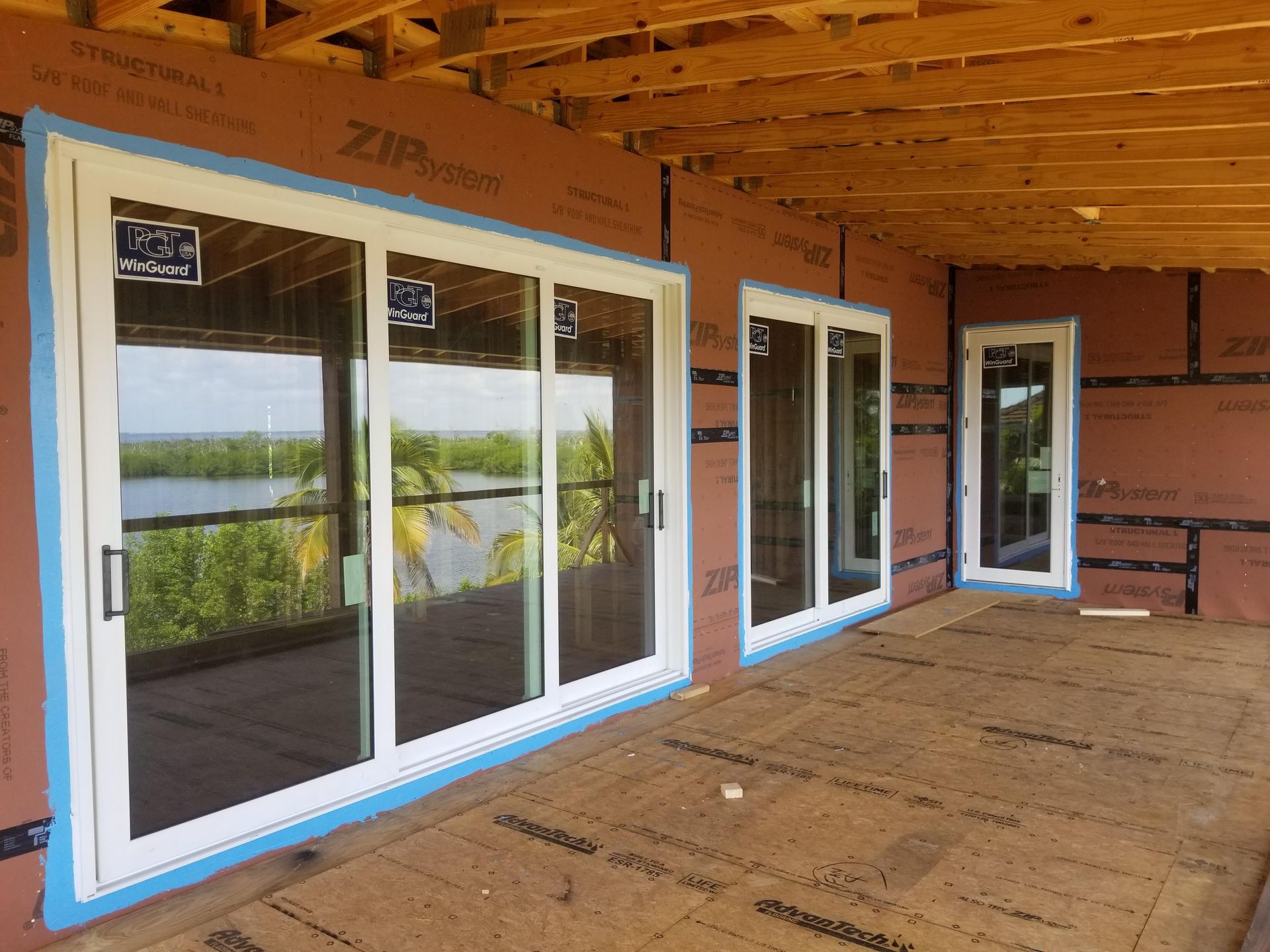 White sliding glass doors and windows on new construction with a waterfront view.