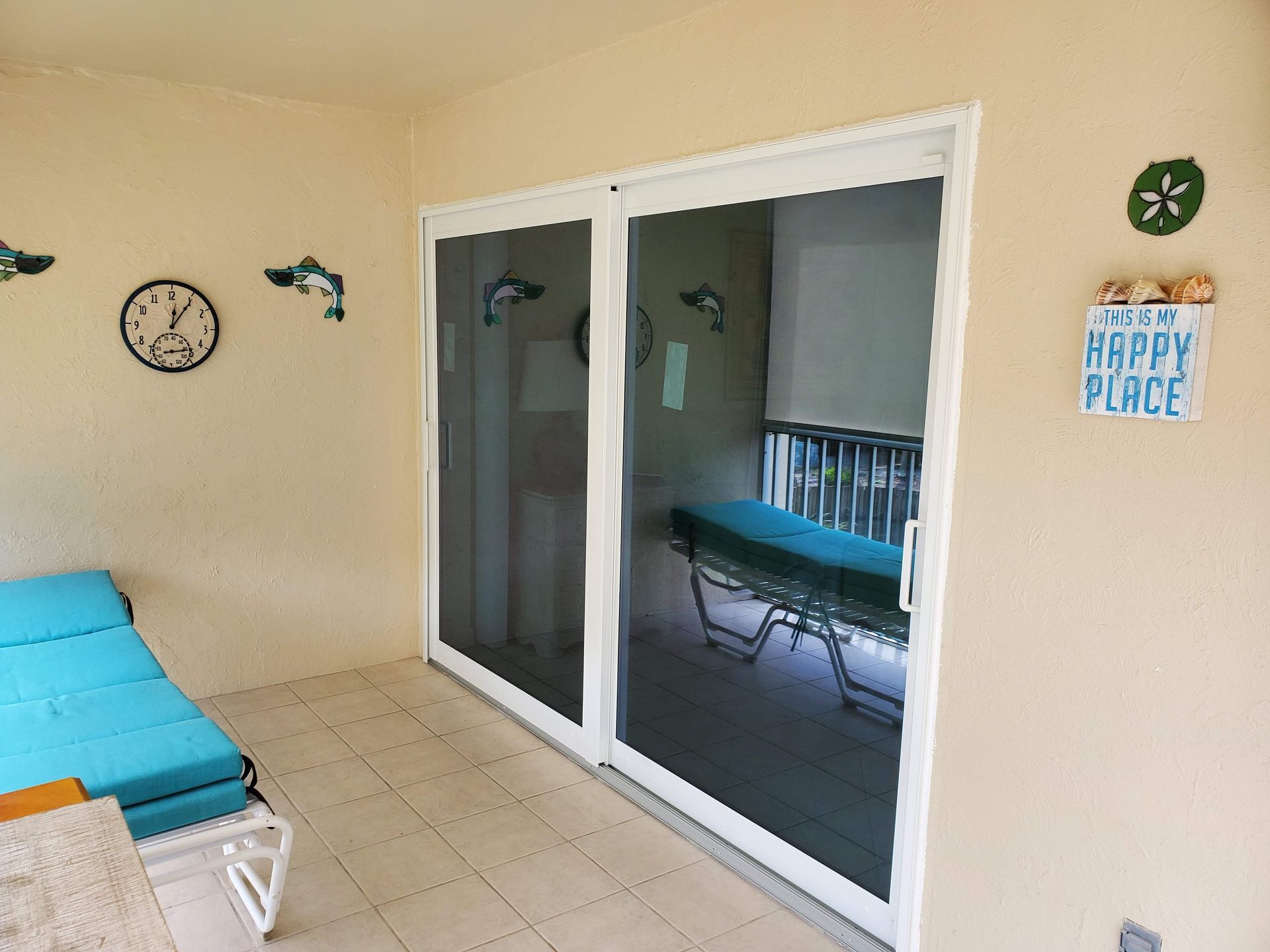 A patio with sliding glass doors, a chaise lounge, and beach-themed decorations.