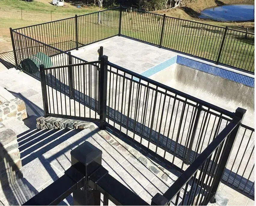A Deck With A Black Railing And Stairs Leading To A Pool — Rockhampton Powdercoating & Fence Panels in Park Avenue, QLD