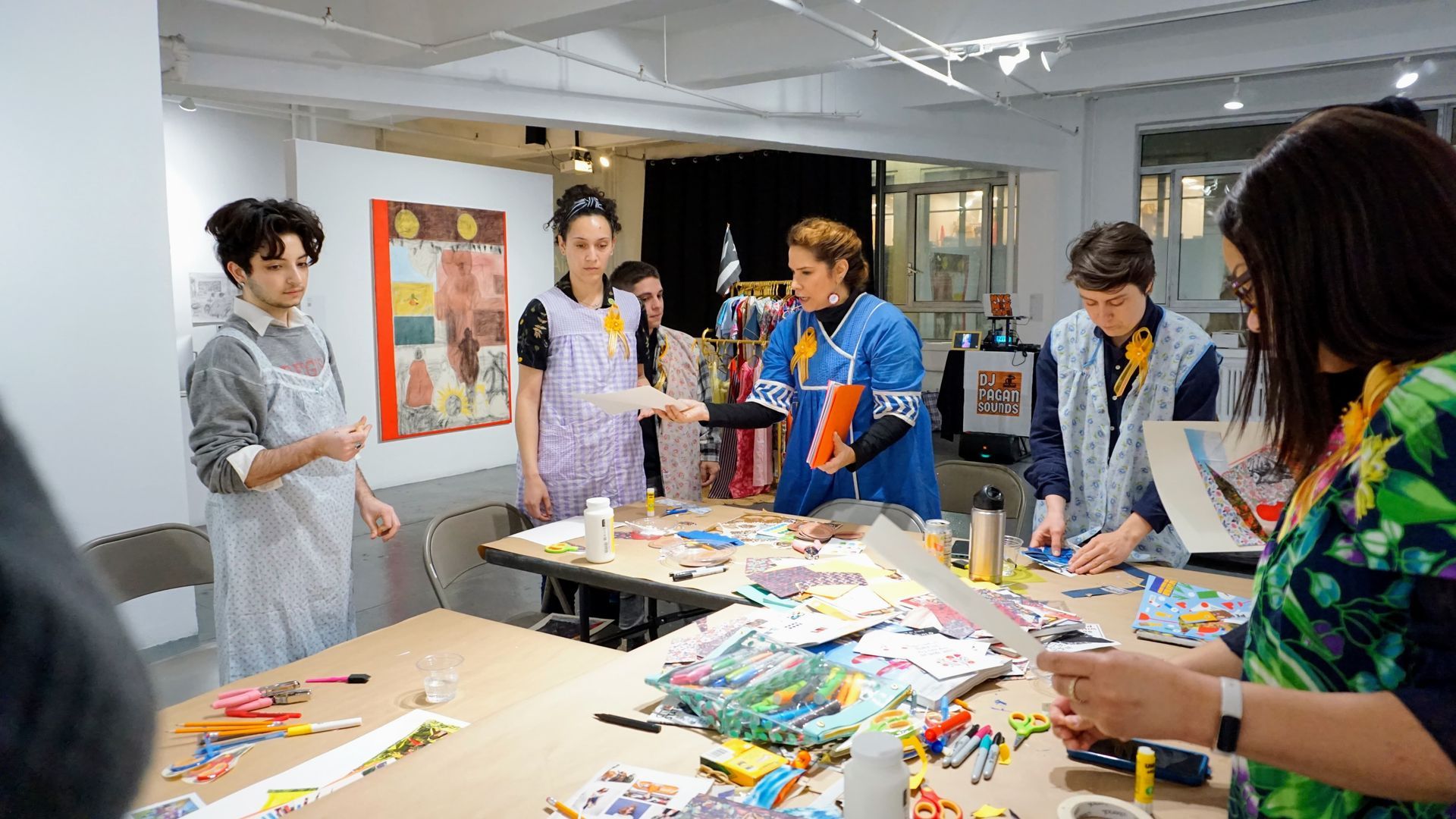 People gathered around a table in a bright art studio, working on colorful crafts and sketches.