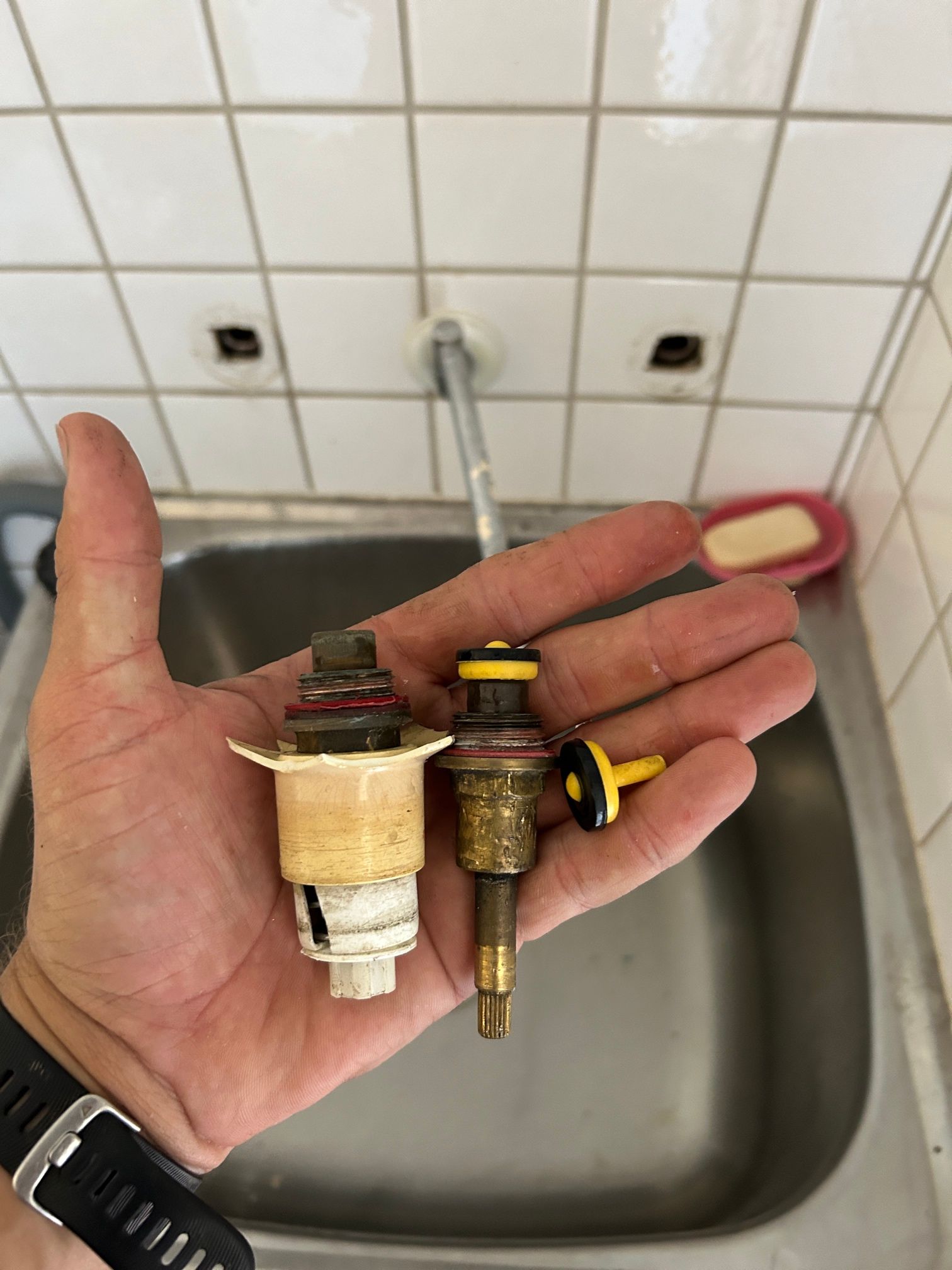Taps parts being held over sink