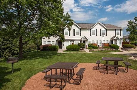 a house with a picnic area in front of it .