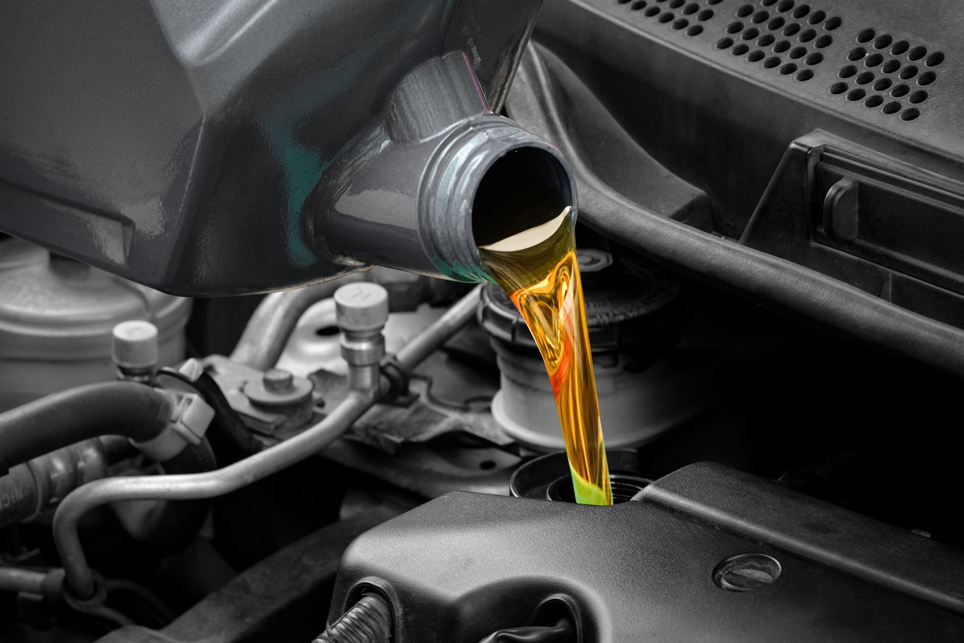 Motor oil being poured into a car engine through the filler cap