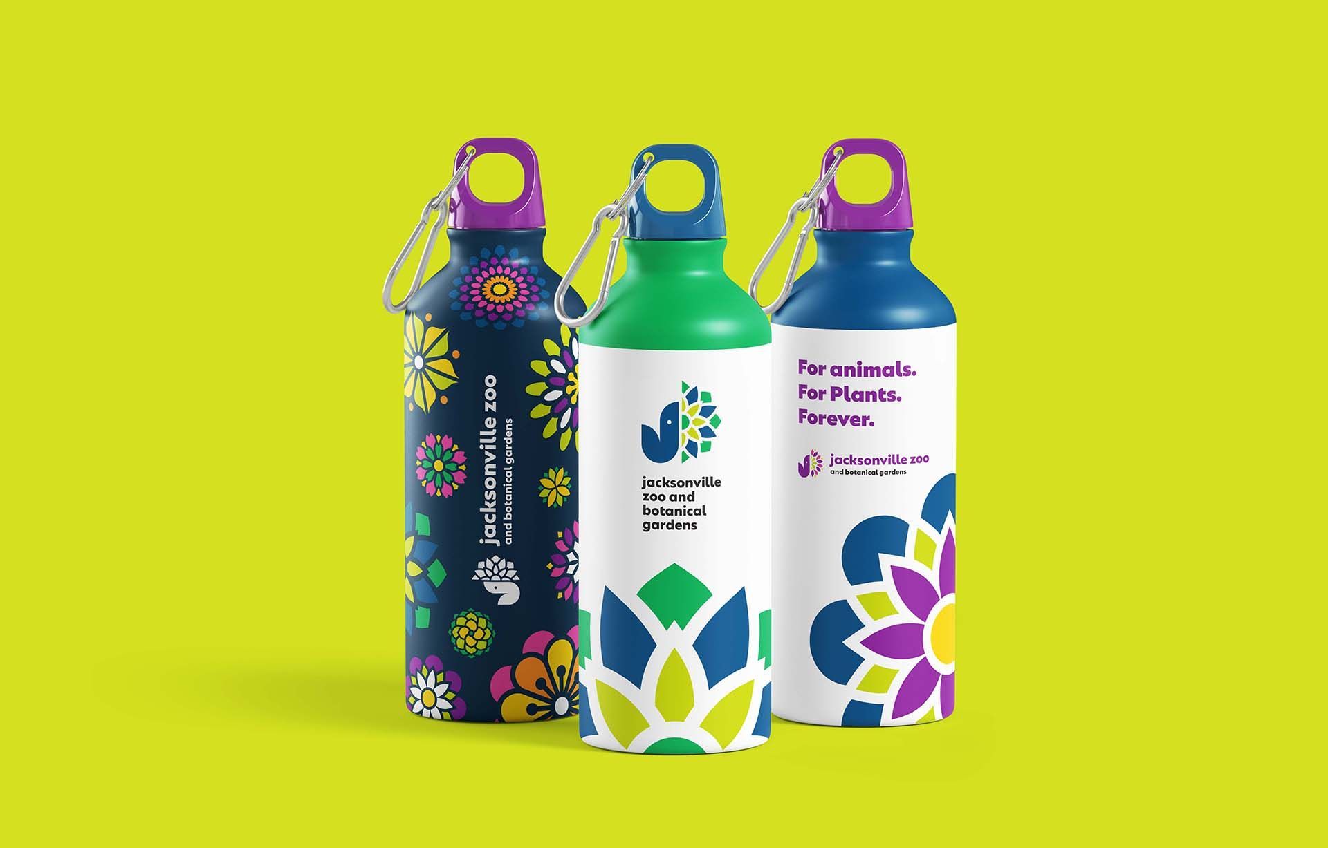 Three colorful reusable water bottles with floral patterns on a bright lime background.