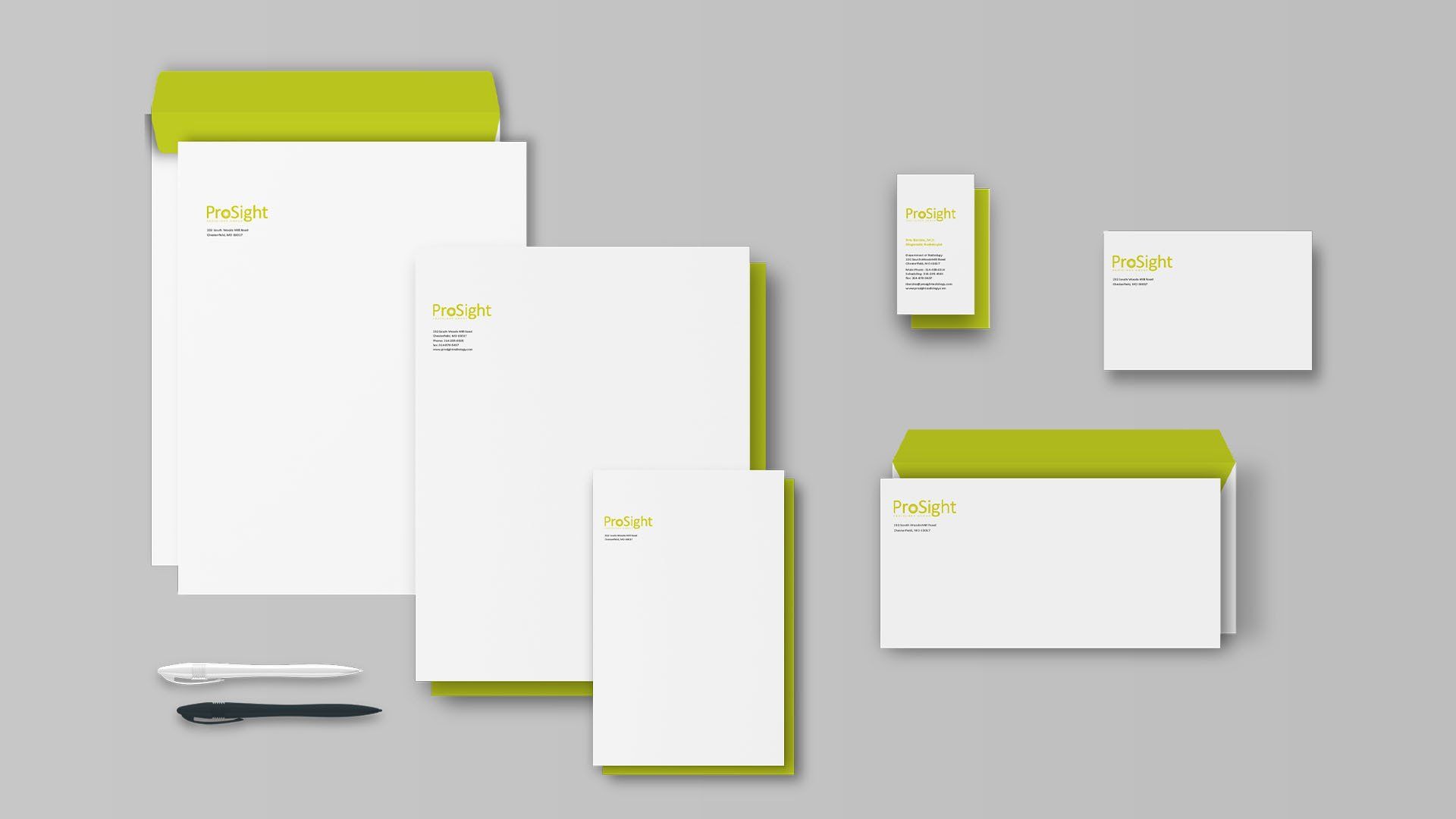 A set of envelope , letterhead , business card , and pen on a gray background.