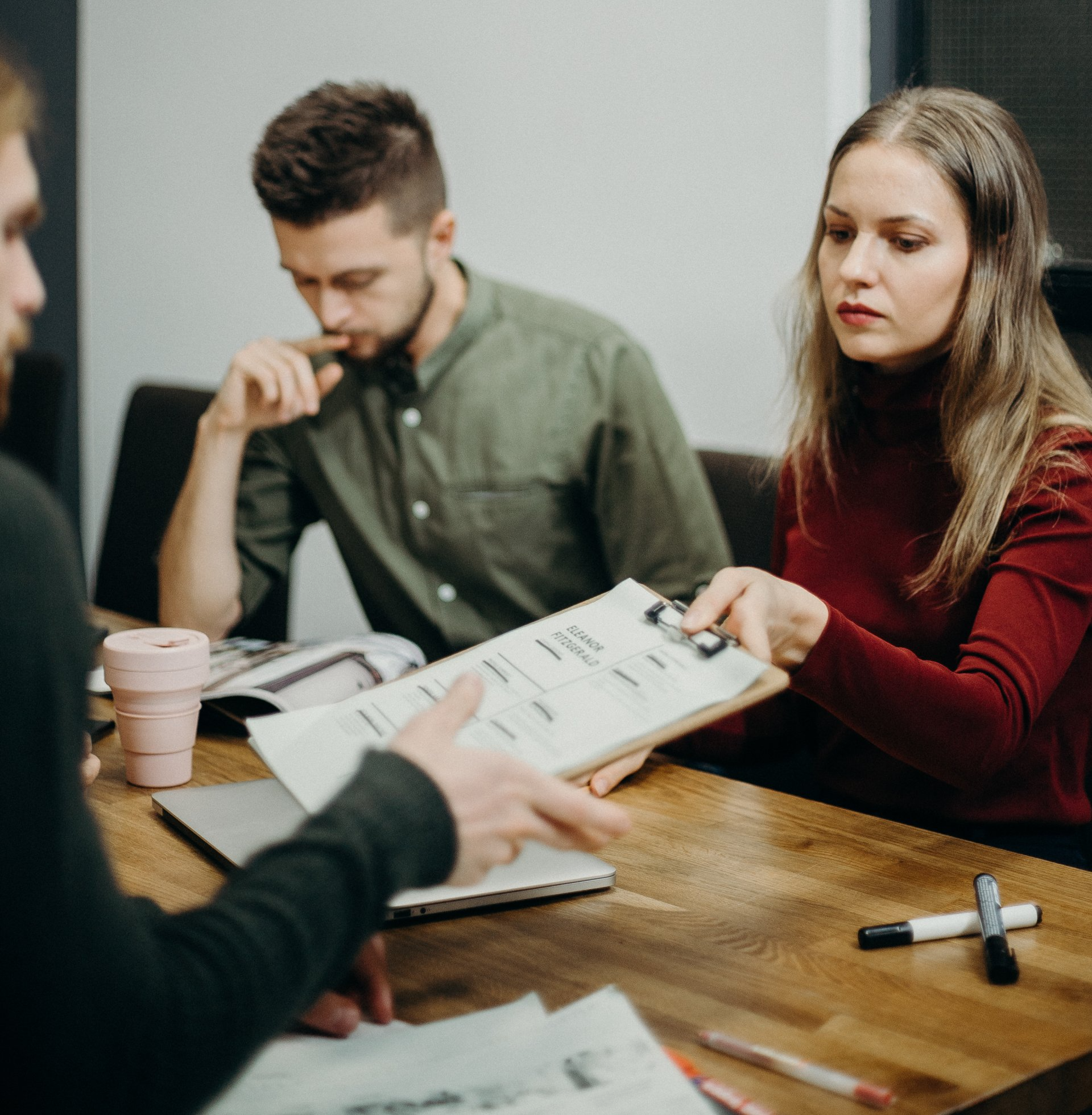 A group of people are sitting around a table looking at papers