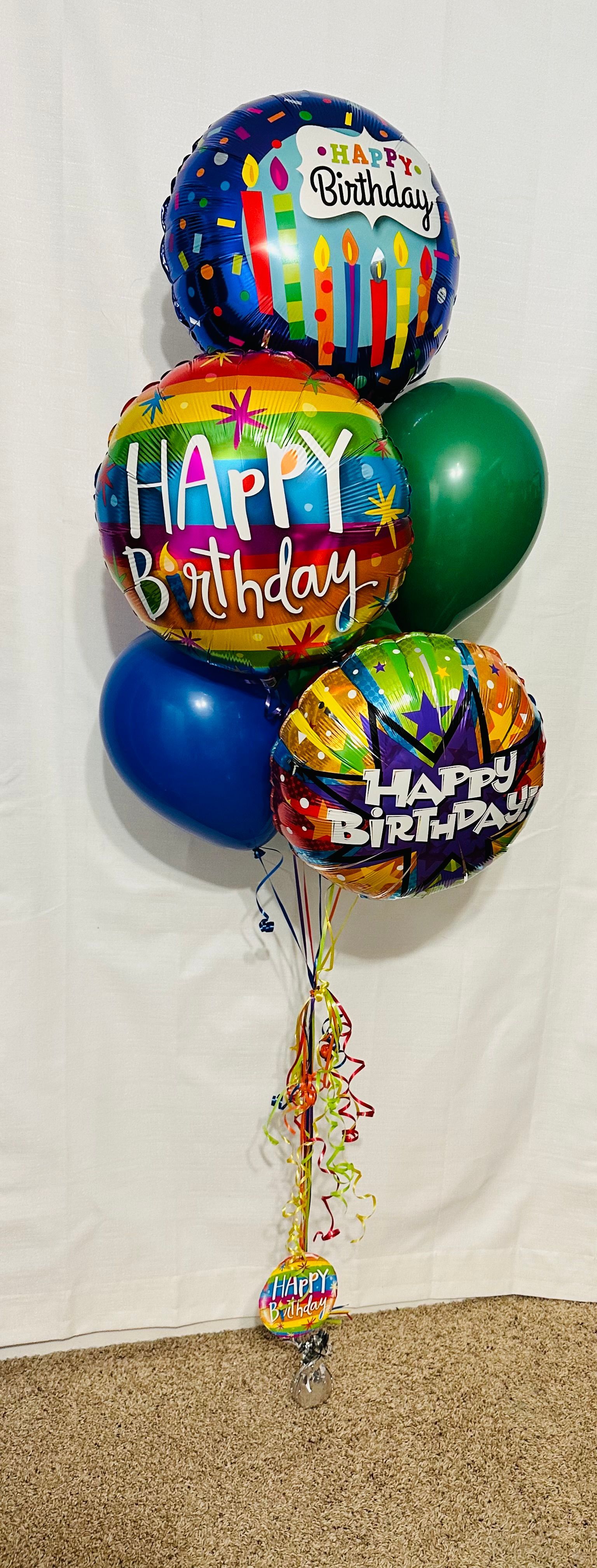 A bunch of birthday balloons are sitting on a table.