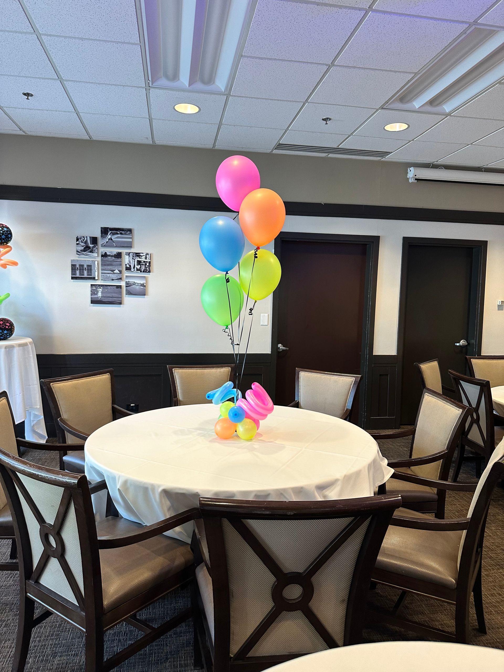 A room with tables and chairs and balloons on them