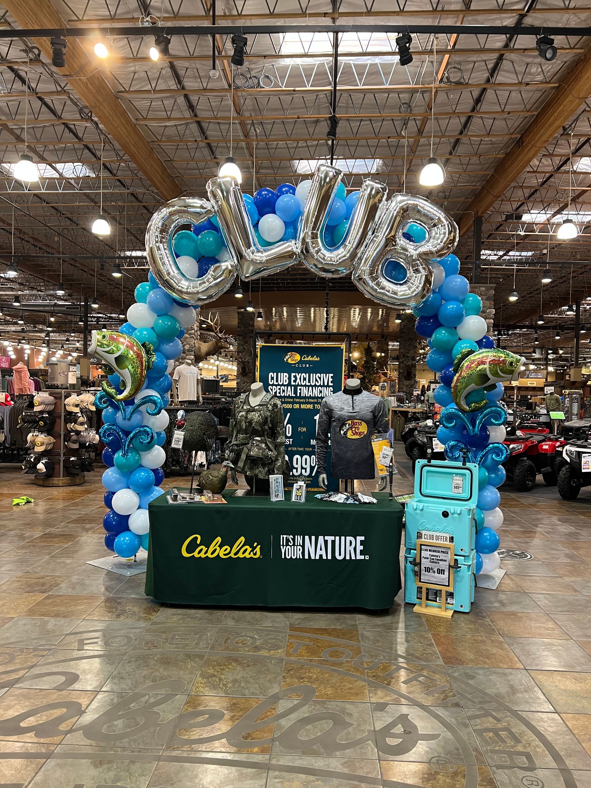 A balloon arch in a store with a table in front of it.