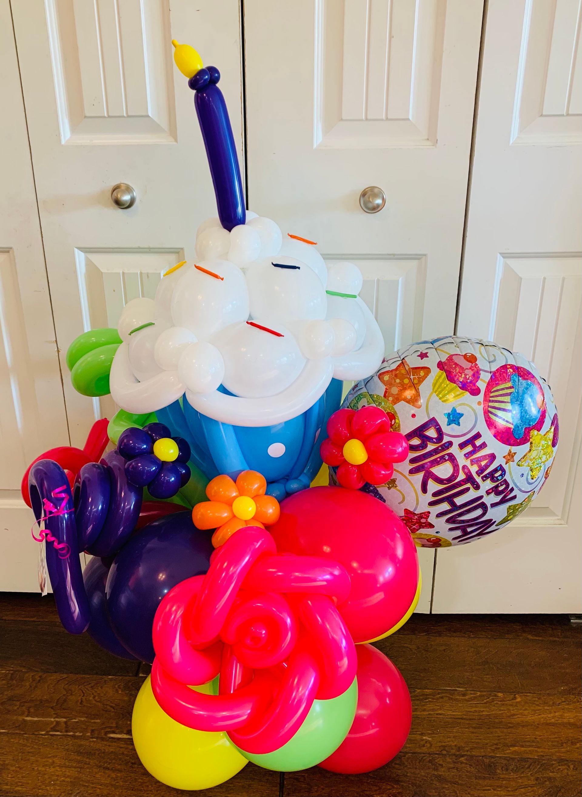 A cupcake made out of balloons with a candle on top