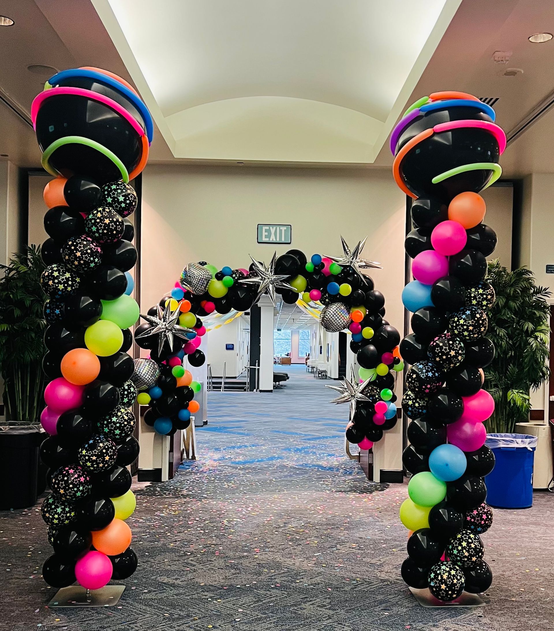 A hallway decorated with balloons and a sign that says exit