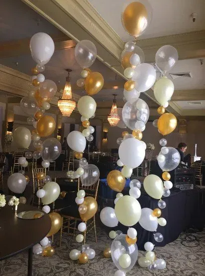 A bunch of balloons are hanging from the ceiling in a room.