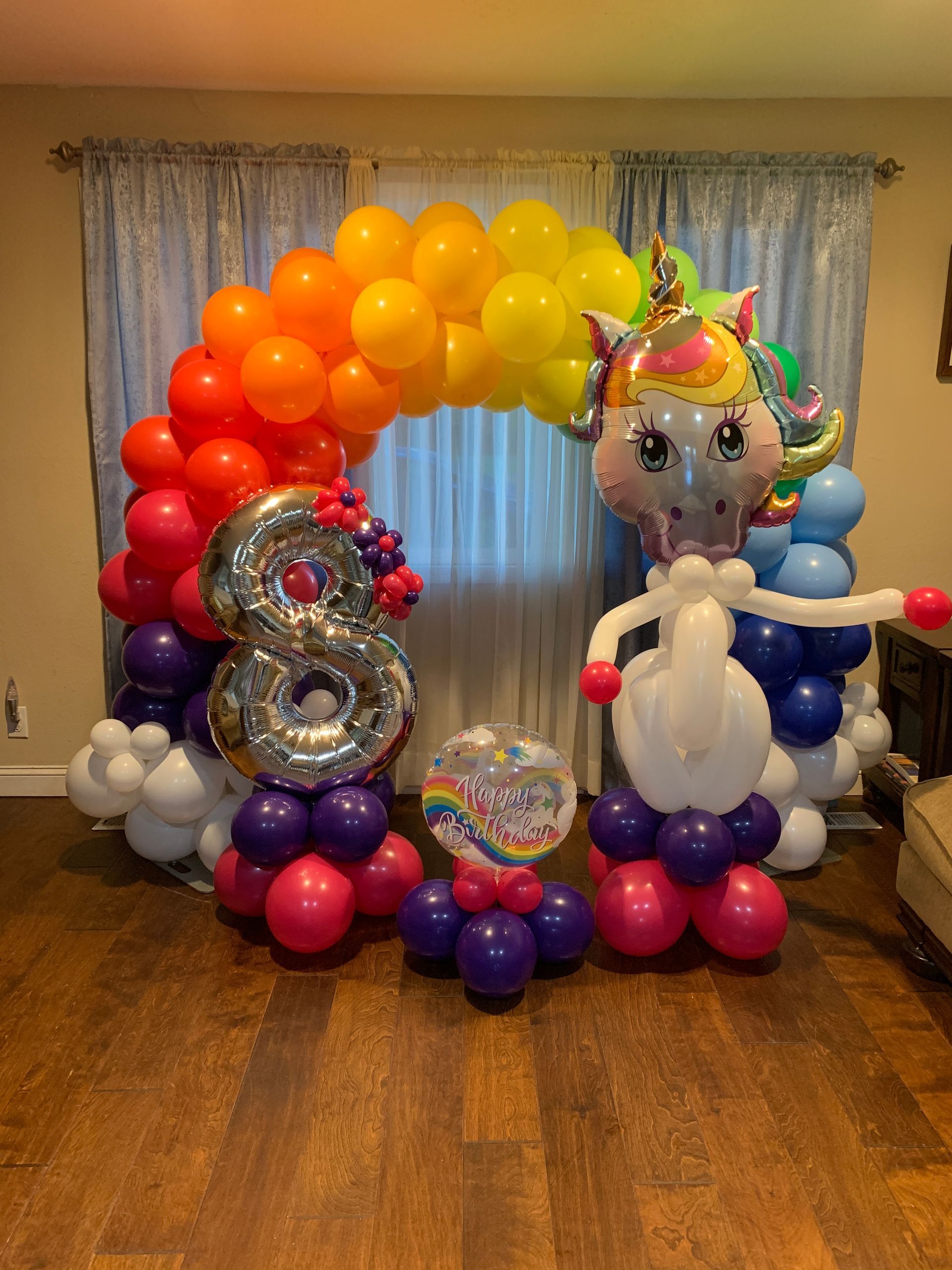 A room filled with balloons and a unicorn balloon.