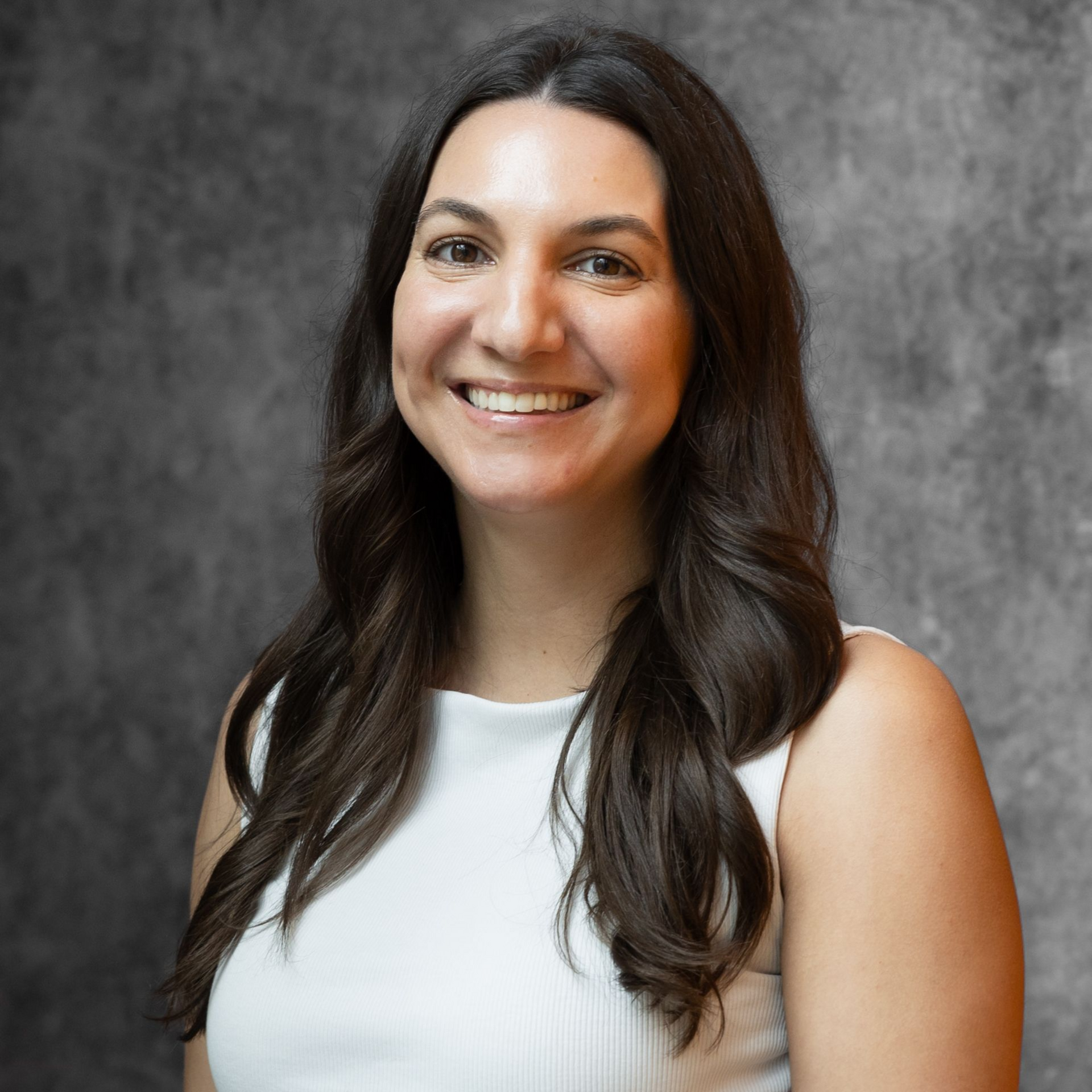 Hannah Werno in a white sleeveless top against a gray background