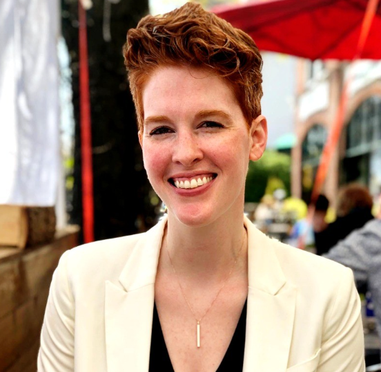 Katie McPollom in a white blazer at an outdoor event