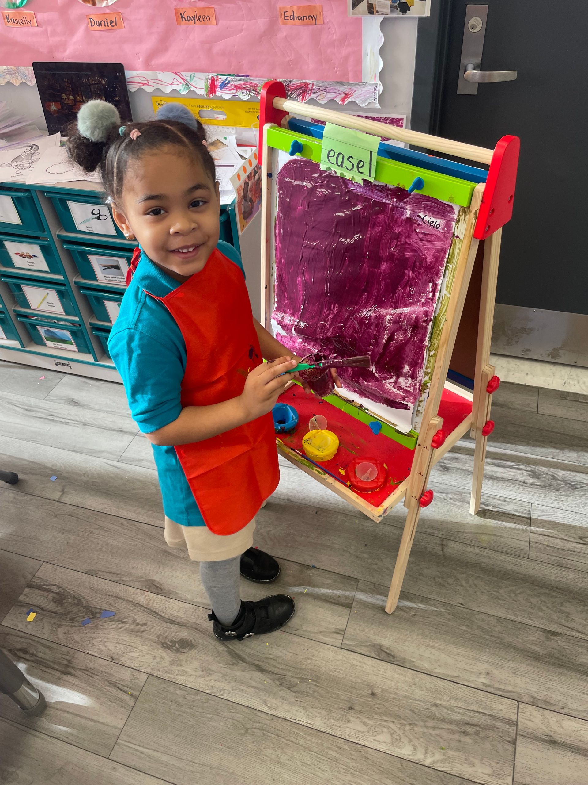 student shows art work at school in the square bilingual early childhood center