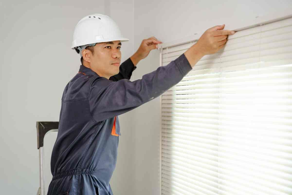 A professional installer putting the finishing touches on a set of custom luxury blinds at Fabric Works near Spokane ,Washington(WA)
