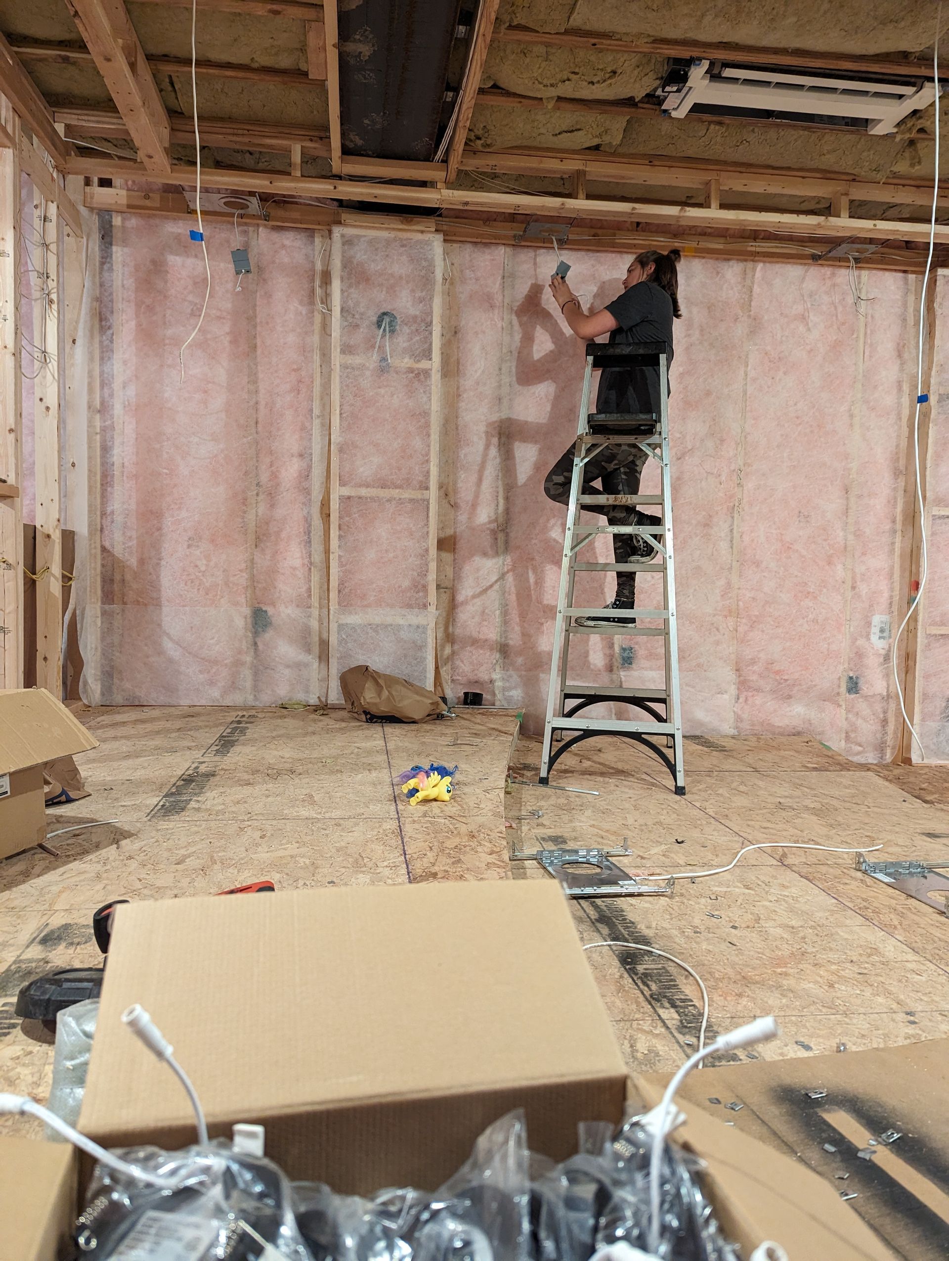 A man is standing on a ladder in a room.