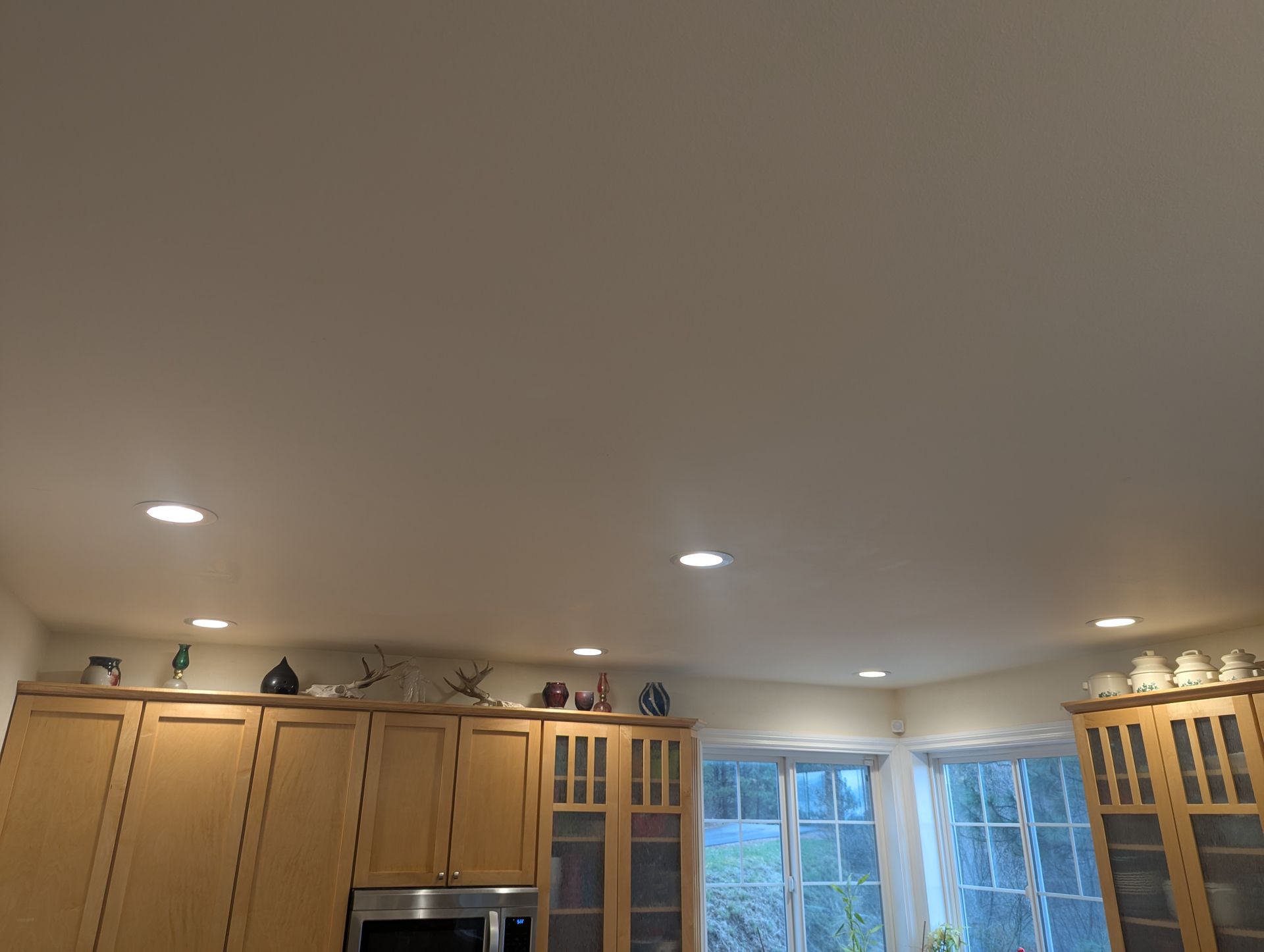 A kitchen with wooden cabinets and a white ceiling.