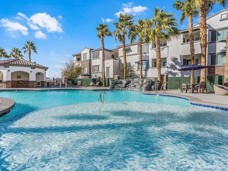 Resort-style swimming pool with a tanning ledge and cabana