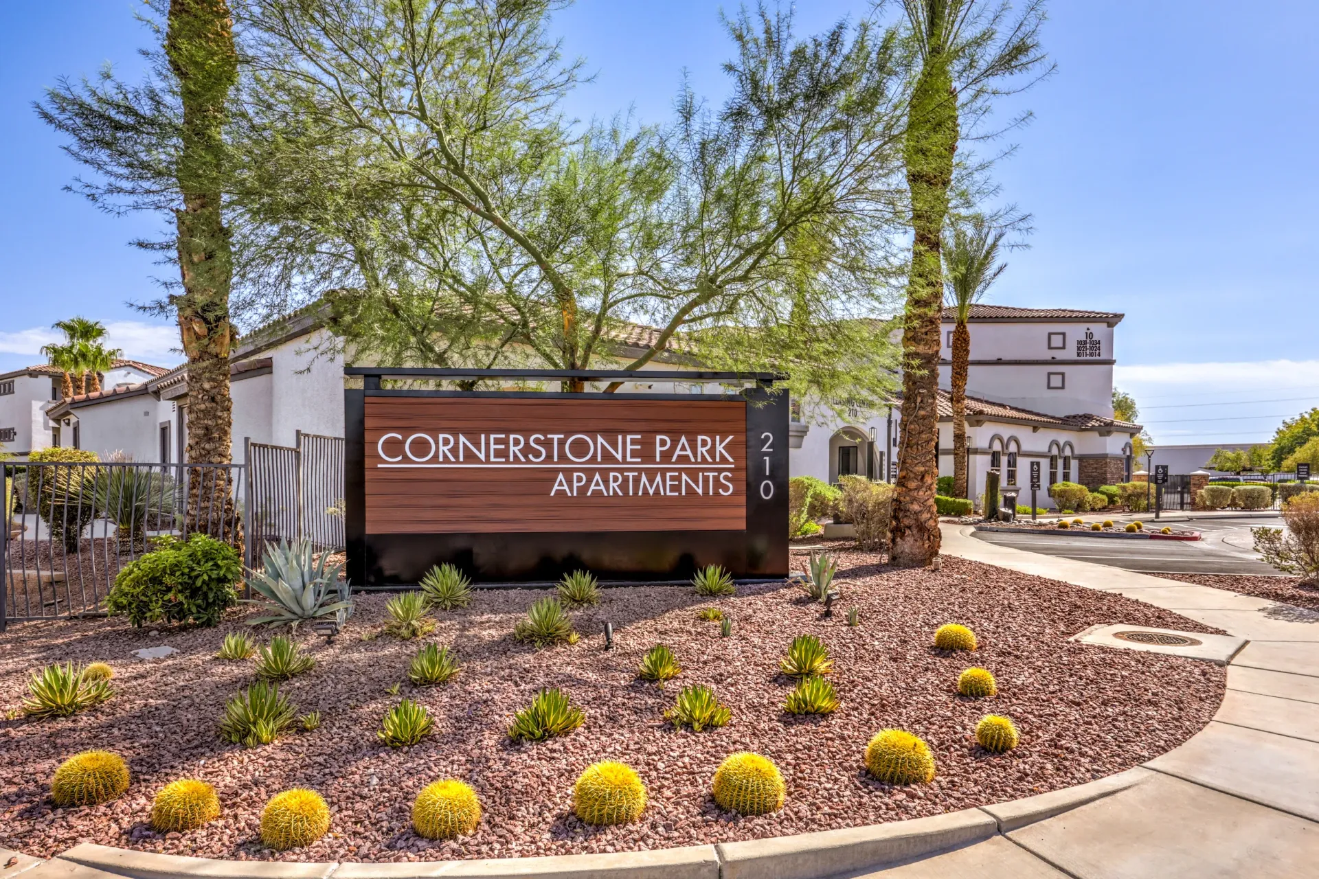 Cornerstone Park Apartments monument sign with desert landscaping and building exterior in the background.