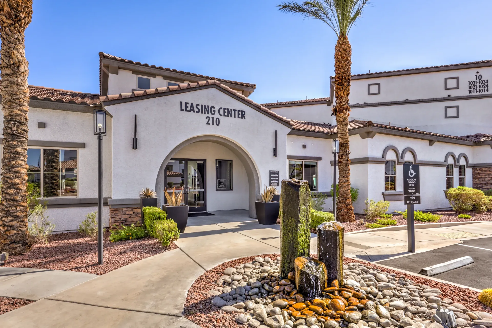 Leasing center exterior with palm trees and a water feature at Cornerstone Park in Henderson, NV.