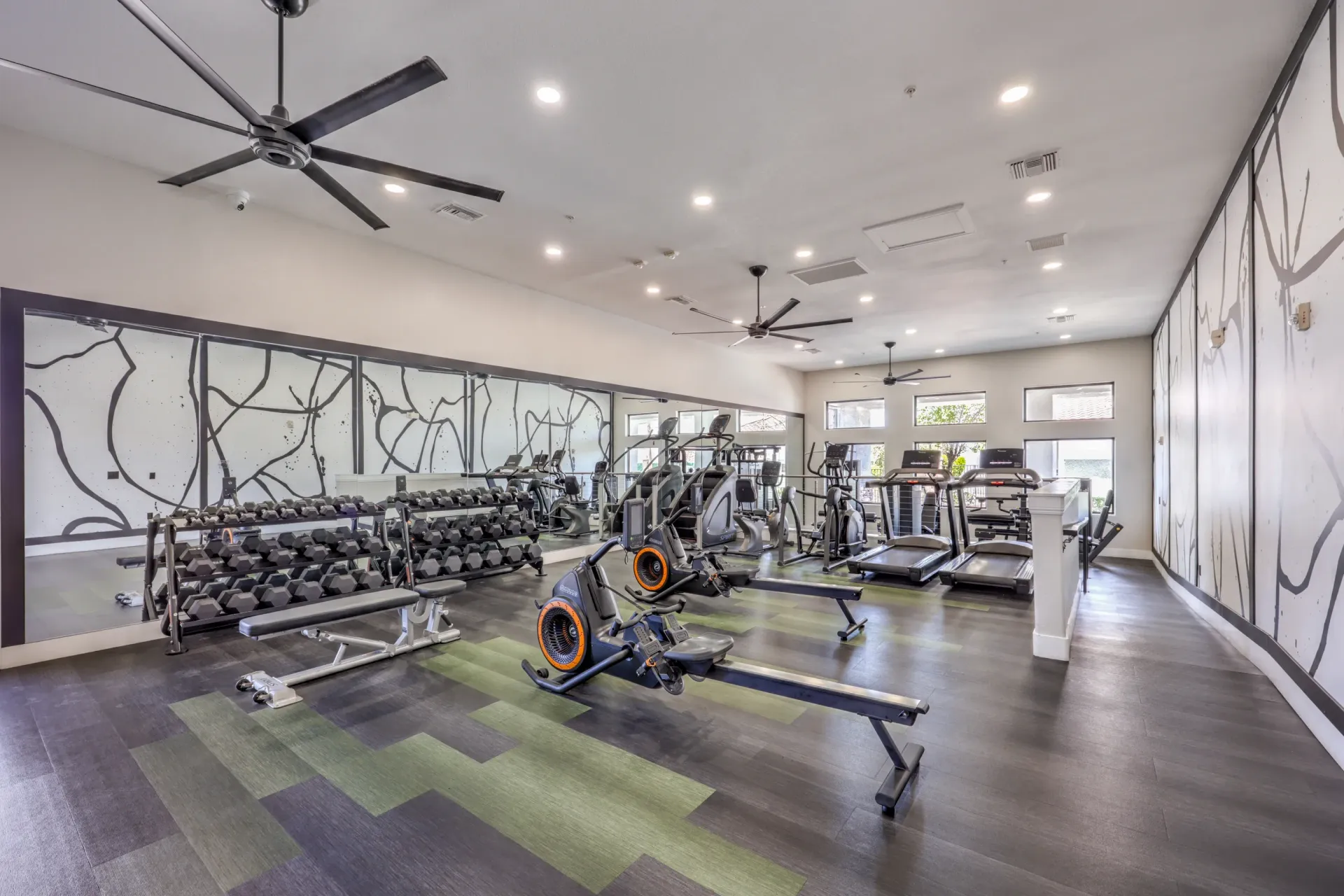 Gym with treadmills, ellipticals, rowing machines, and free weights.