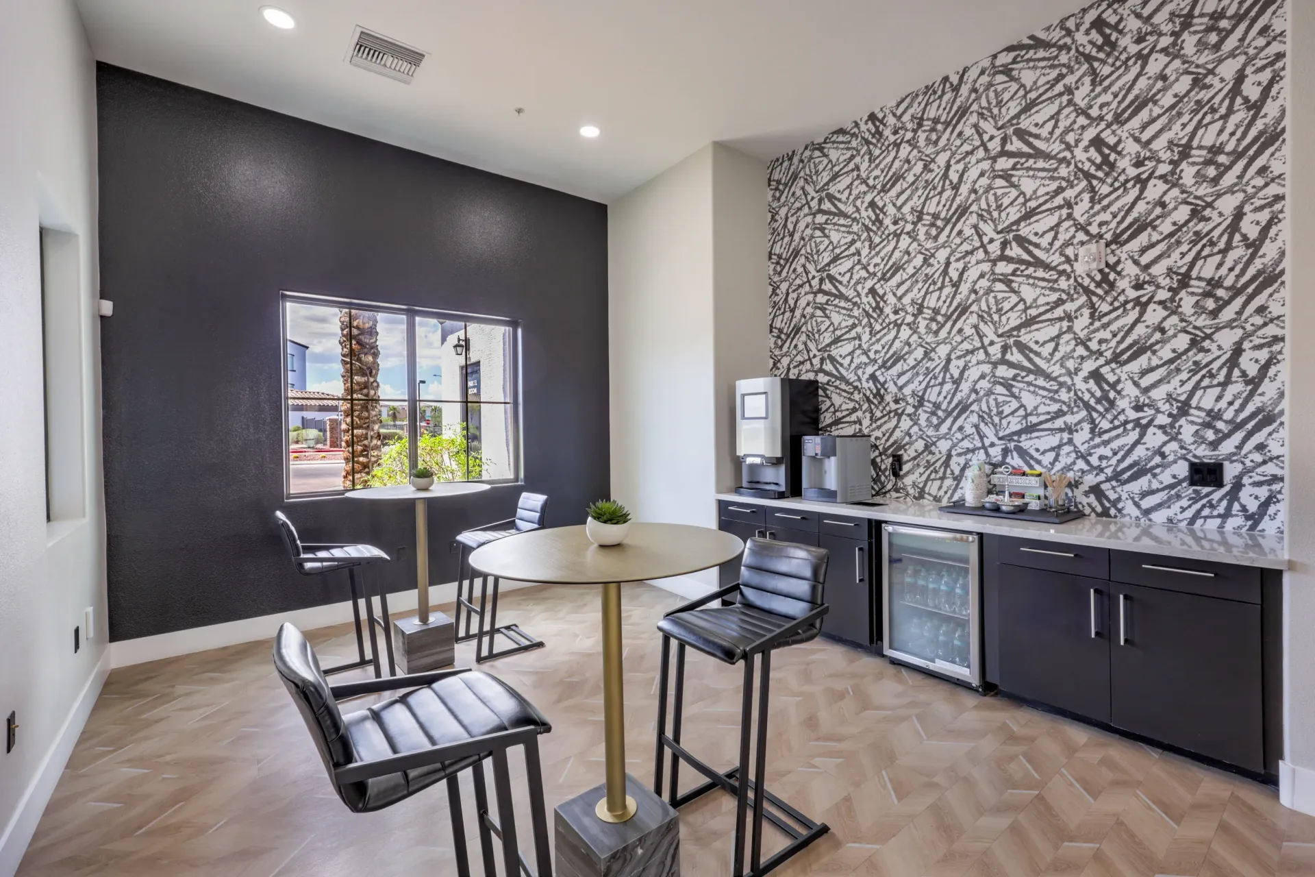 Community coffee bar area with high-top tables and stools, and a coffee station with a mini-fridge at Cornerstone Park in Henderson, NV.
