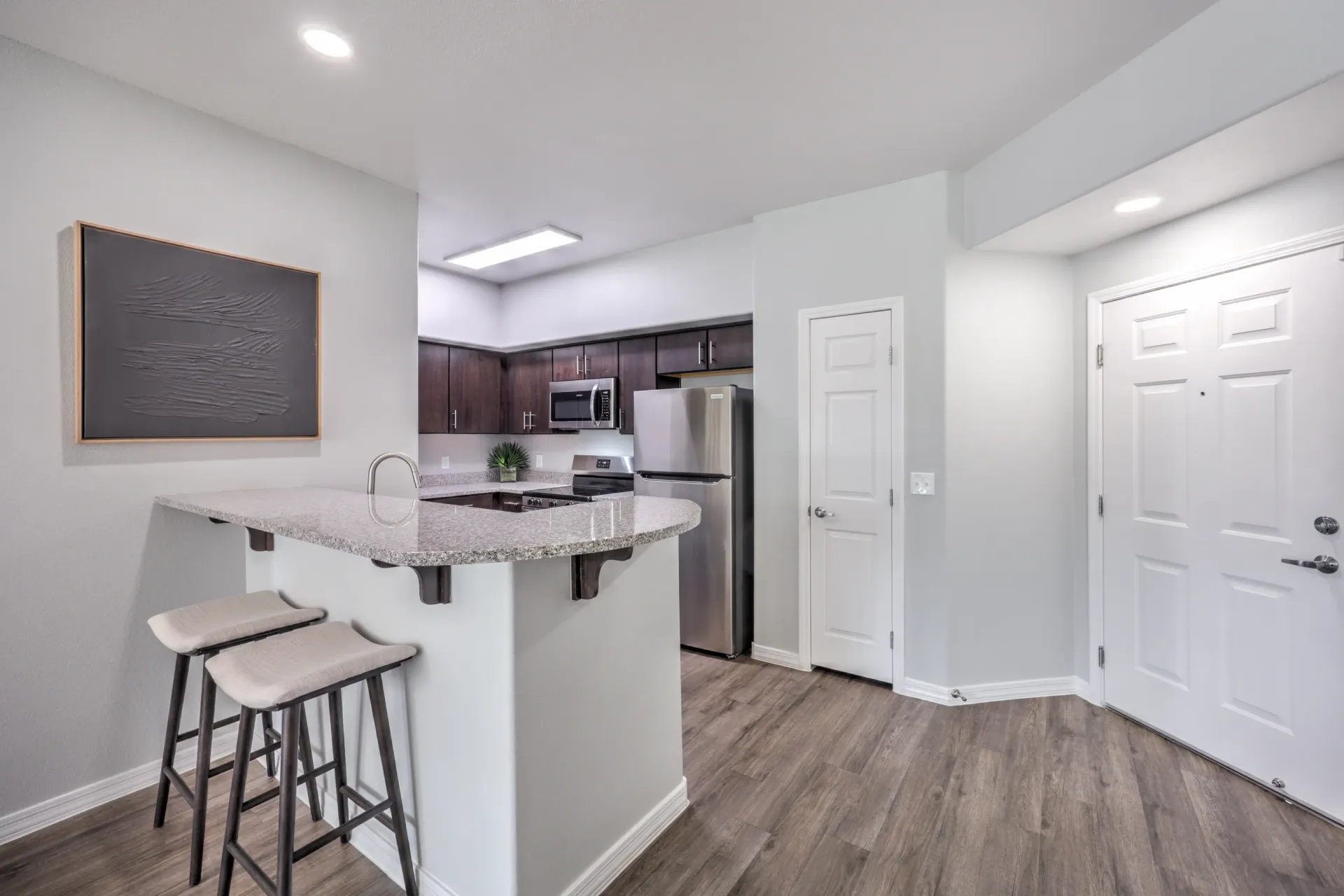 Modern kitchen with granite island and stainless steel appliances at Cornerstone Park in Henderson, NV.
