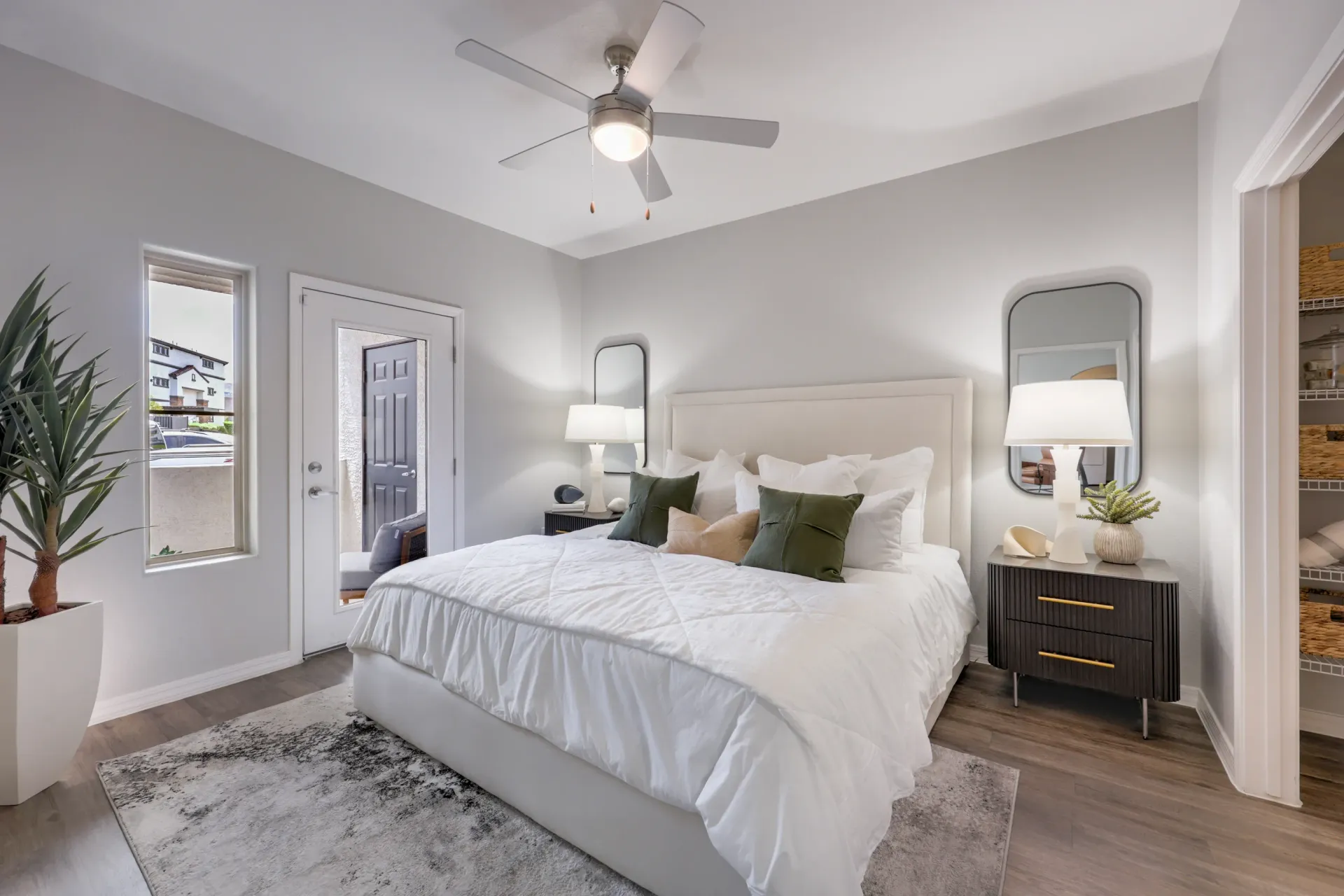 A beautifully appointed bedroom with a large bed, nightstand, and closet at Cornerstone Park in Henderson, NV.