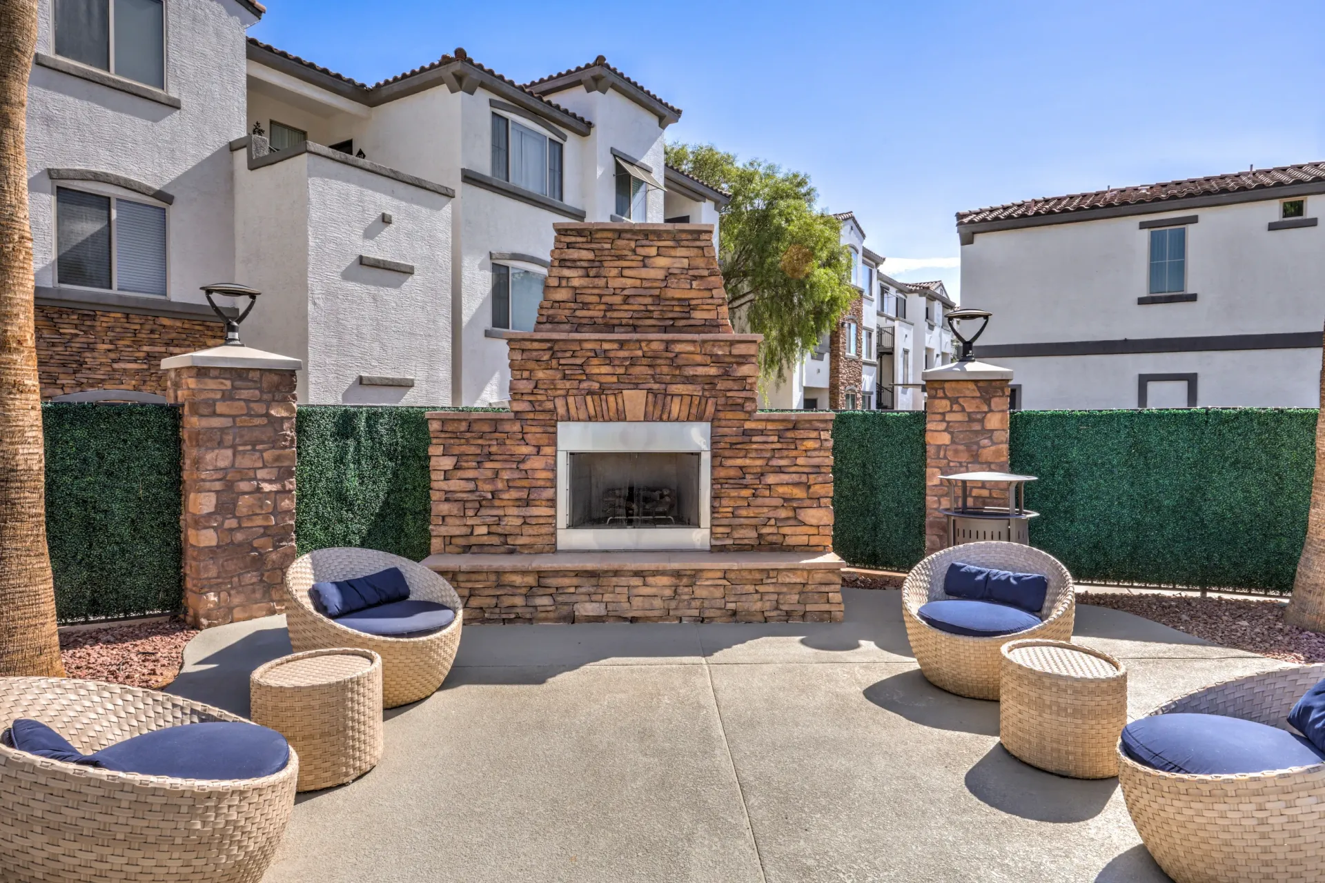 Outdoor seating area with fireplace and modern chairs at Cornerstone Park in Henderson, NV.