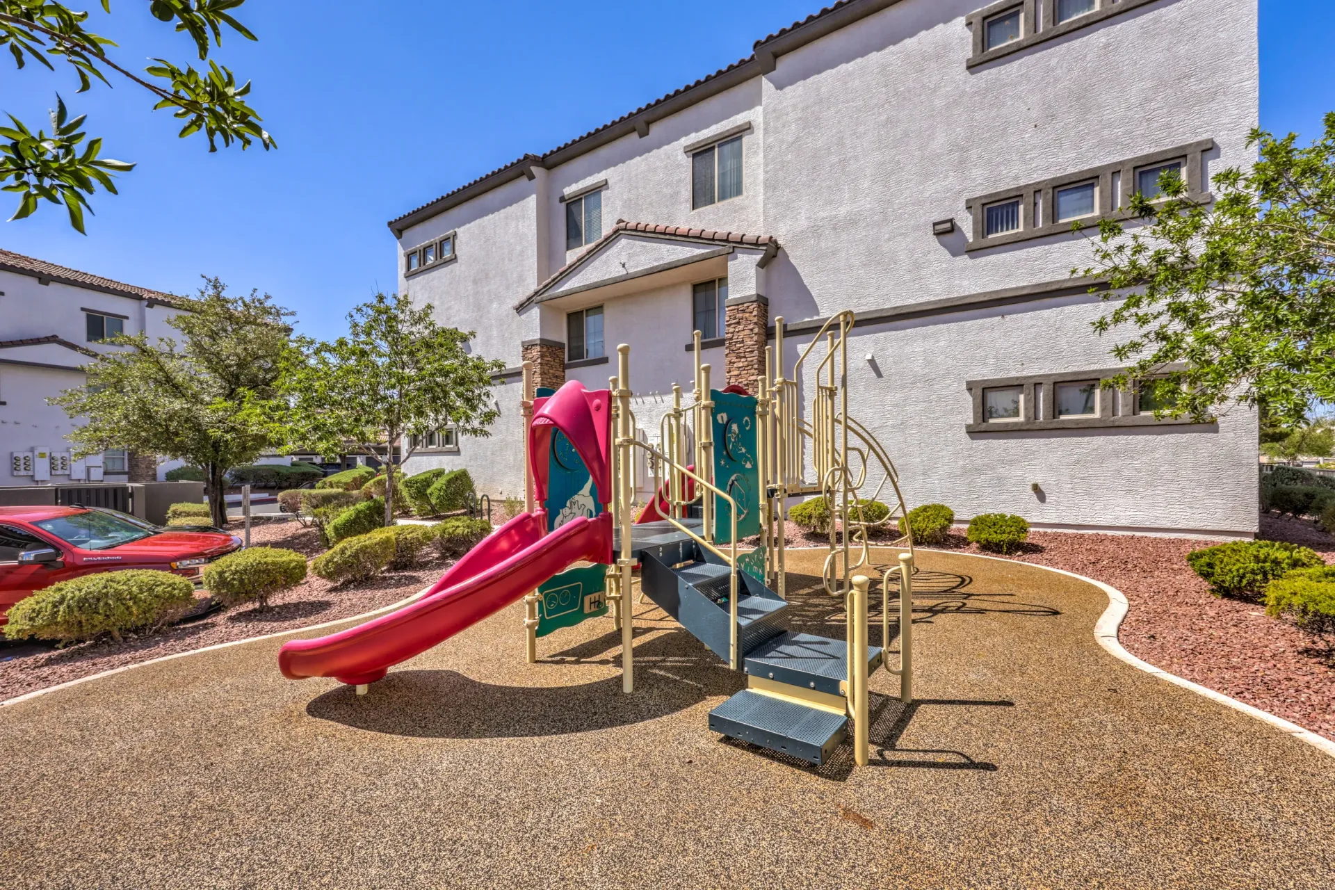 Playground with slides and stairs in front of apartment buildings at Cornerstone Park in Henderson, NV.
